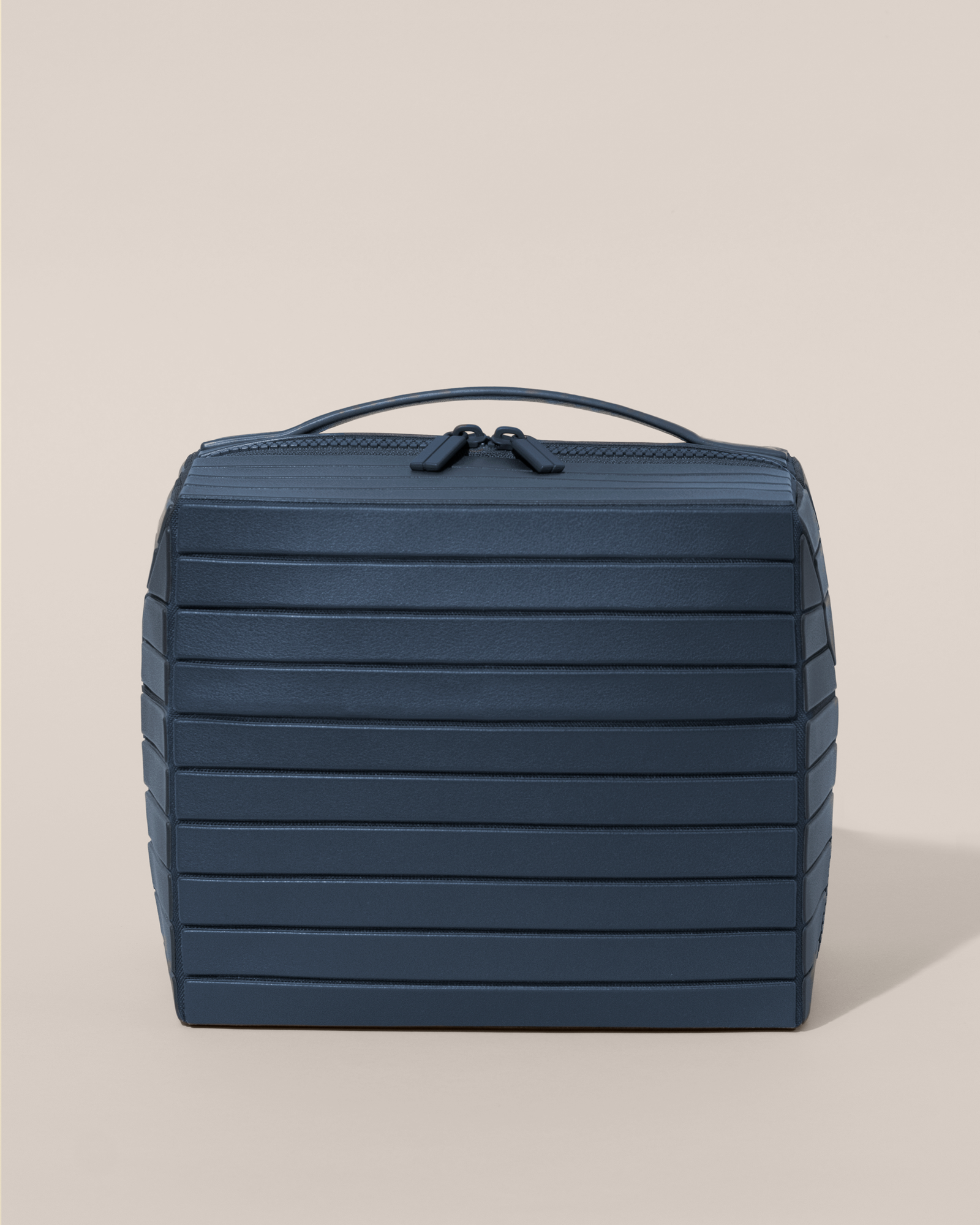 Front view of the closed Afform Large Indigo (blue) Kit toiletry bag with a compact, zip-around design and top handle for elevated everyday or travel organization