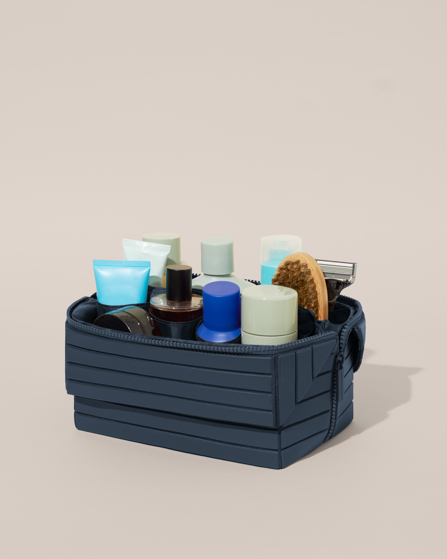 Open Afform Large Indigo (blue) Kit, shown open and packed with grooming essentials like razors, cologne, and skincare. A structured, travel-ready toiletry organizer