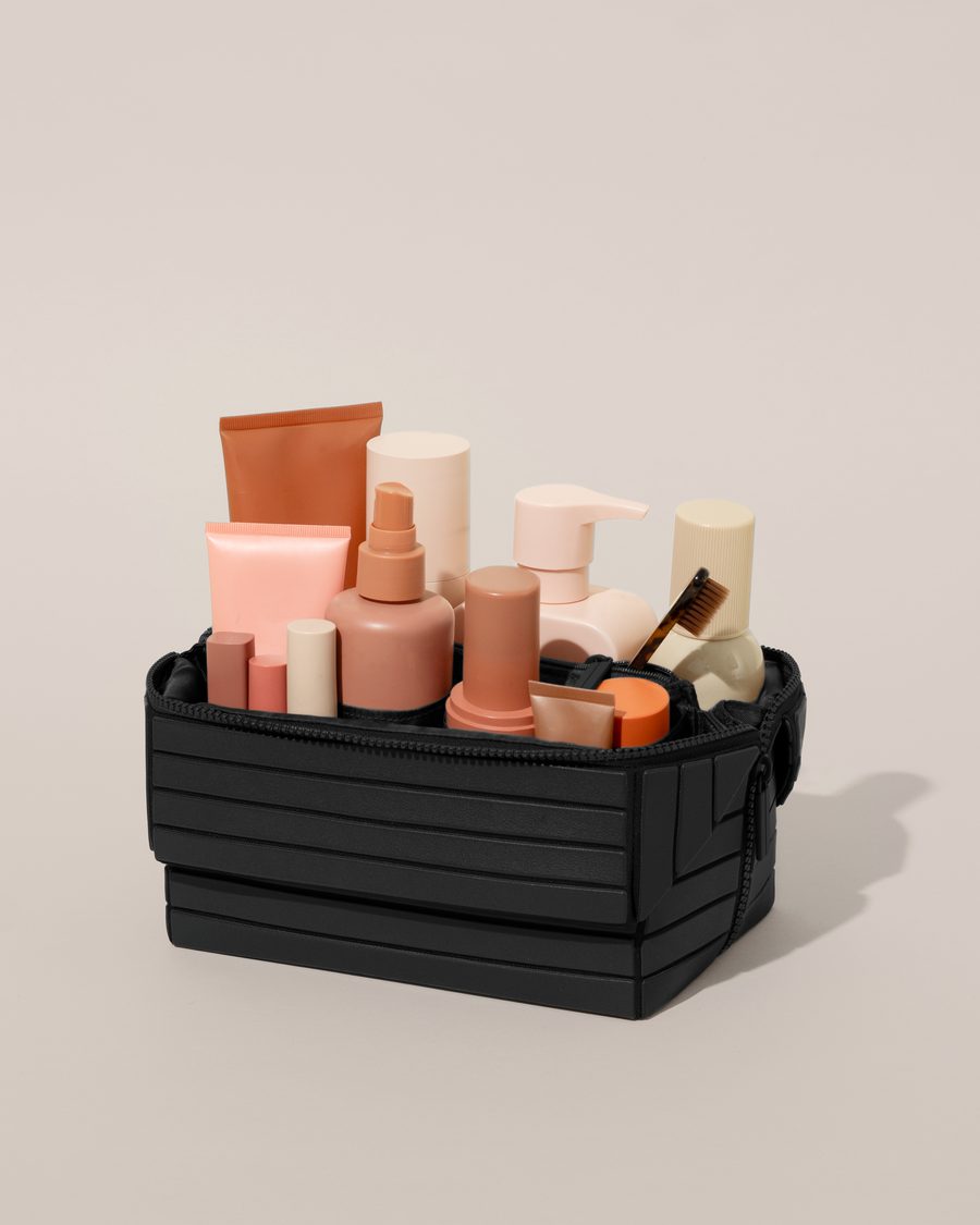 Open Afform Onyx (black) Kit, shown open and packed with skincare and grooming products. A compact, structured toiletry bag designed for visibility and access.