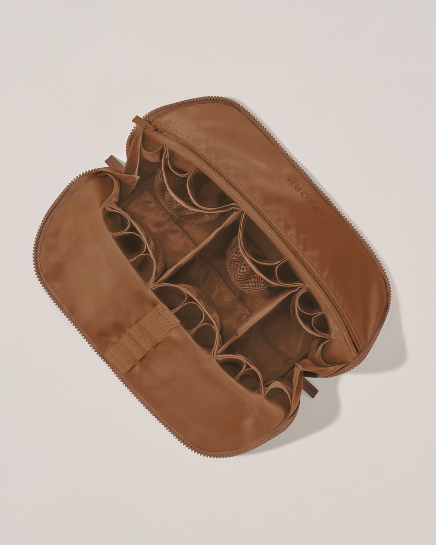 Interior view of Afform Large Vicuna (brown) Traveller makeup bag showing empty pockets, pouches, elastic holders, and zipper pocket for loose items