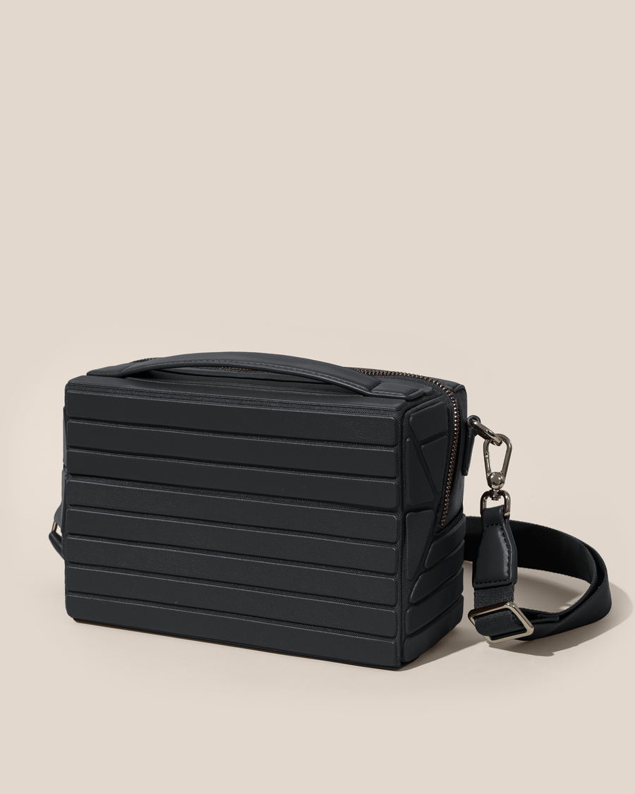 Closed Afform Onyx Crossbody bag with structured horizontal bar design and gold hardware