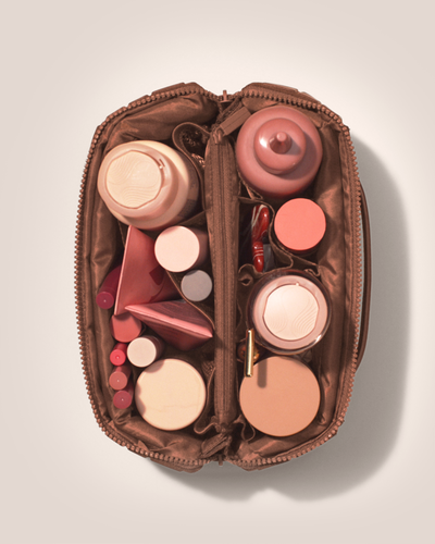 Image of the large kit top down, open with an assortment of full sized toiletries inside of it.