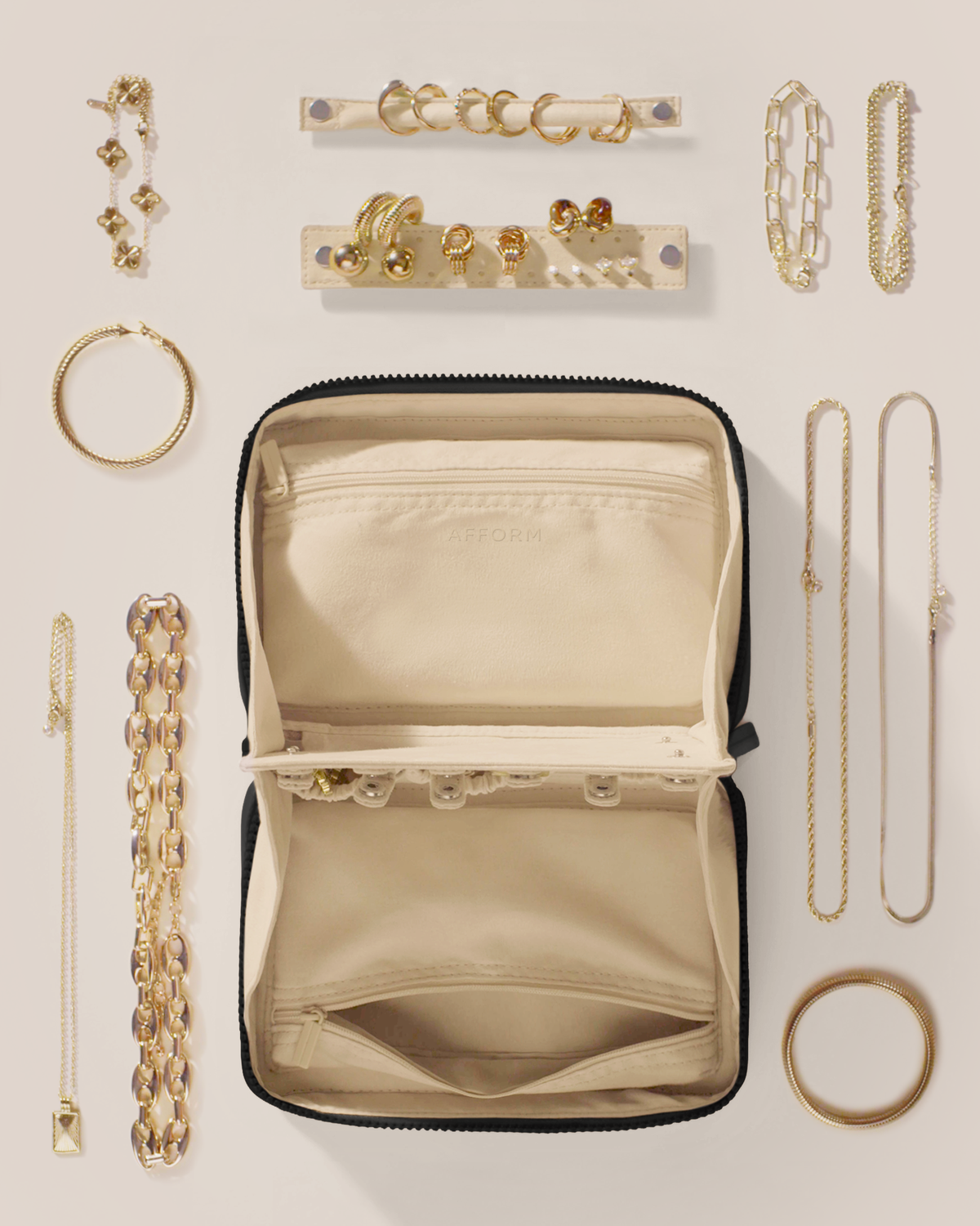 The Large Onyx (Black) Vault shown overhead with all of the products that can fit in it, as well as its detachable ring and earring bars.