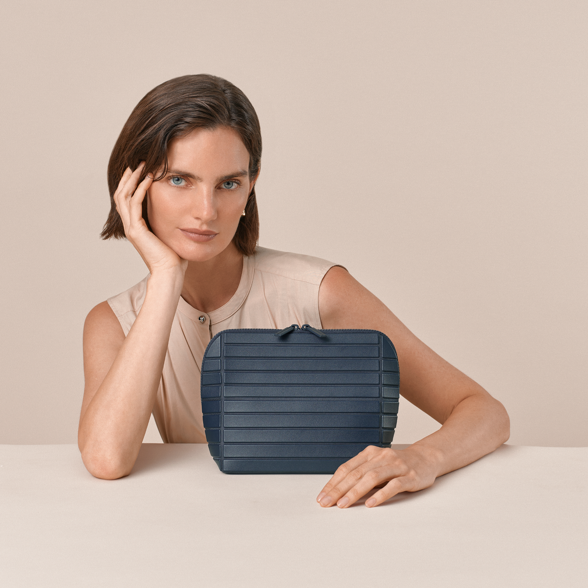The Medium Indigo (Navy) Traveller shown in a stylistic shot with a model. Afform (formerly Parallelle)