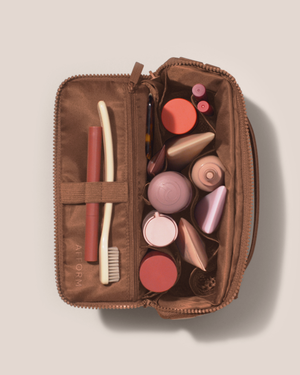 Image of the medium kit top down, open with an assortment of toiletries inside of it.