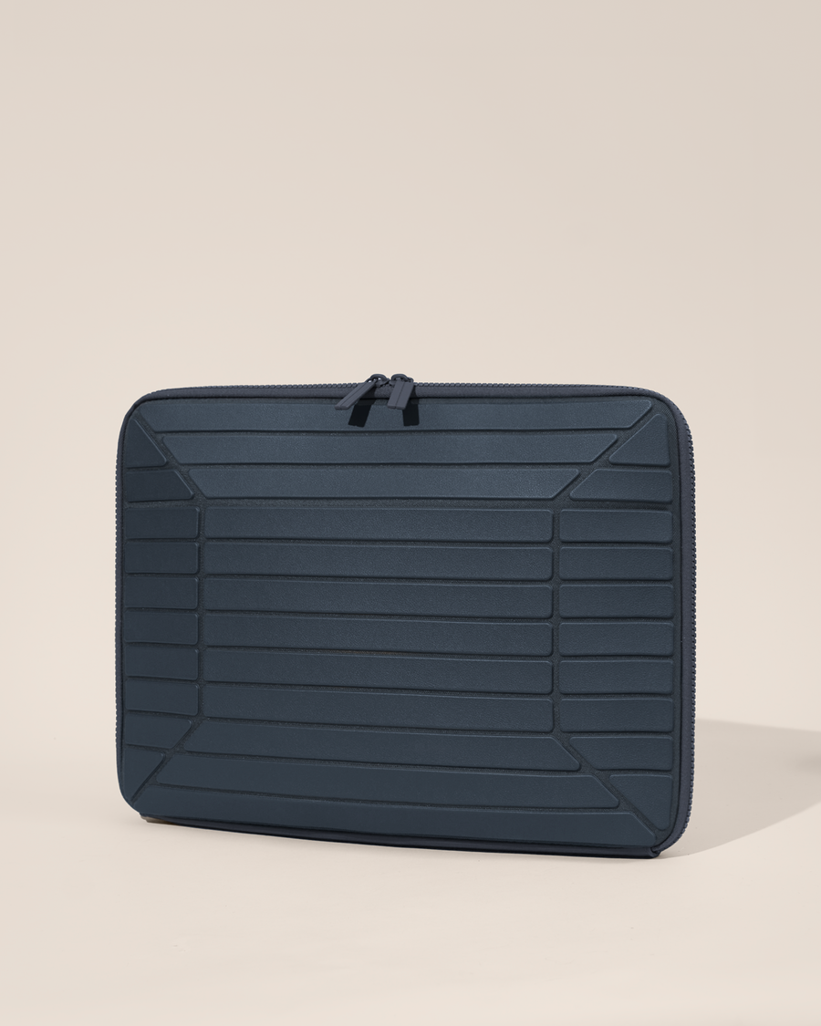 Closed Afform 15" Indigo (navy) Laptop Case closed, exterior view showing structured horizontal bar detail and zipper closure