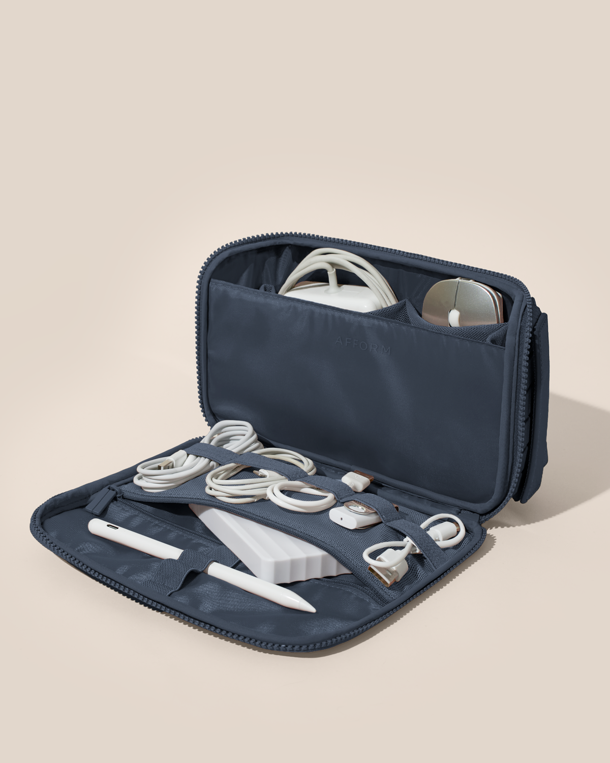 Afform Indigo (navy) Tech Kit electronics organizer shown open and packed with a laptop charger, mouse, phone charger, USB drive, stylus, and more