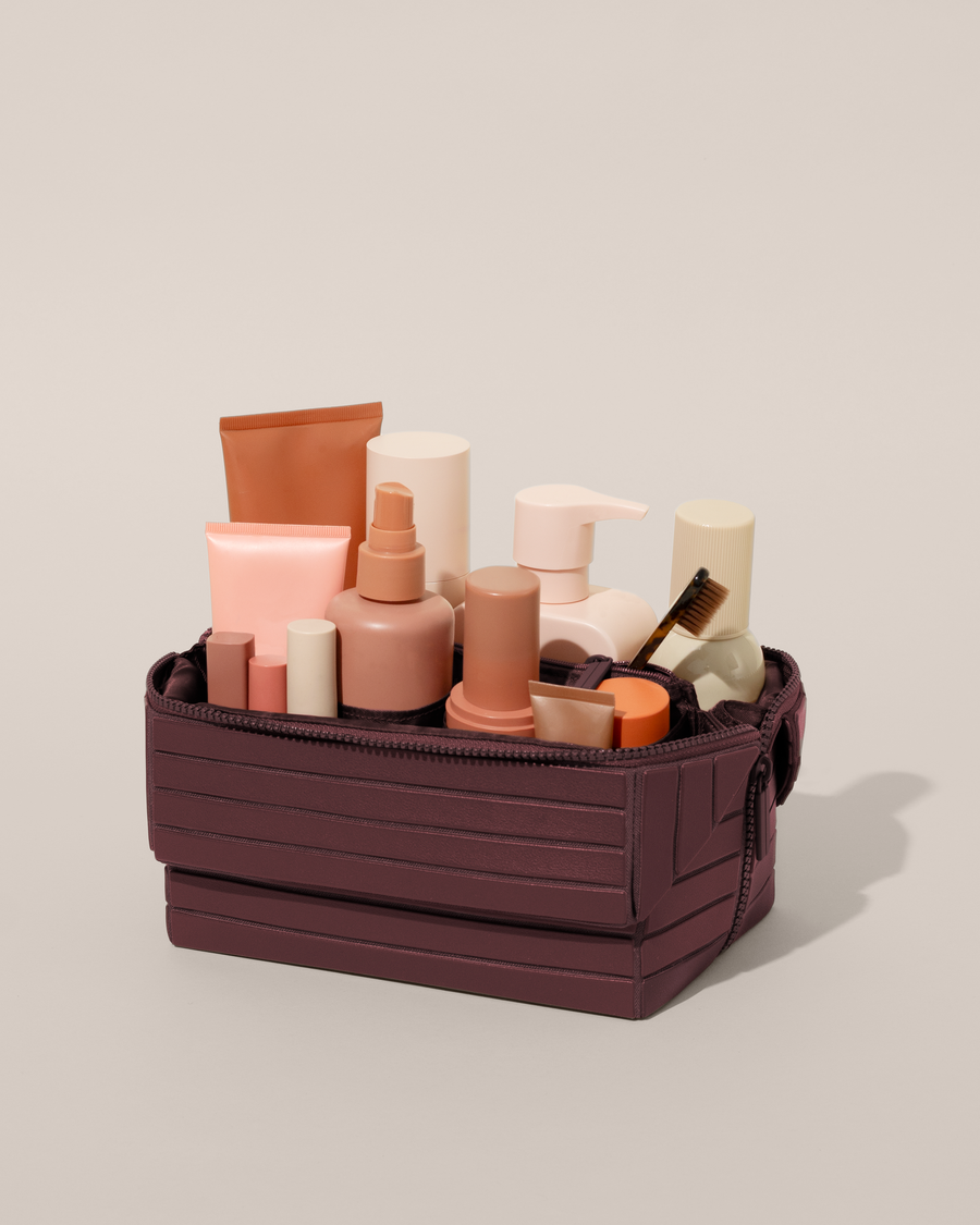 Open Afform Large Cassis (maroon) Kit, shown open and packed with skincare and grooming products. A compact, structured toiletry bag designed for visibility and access.