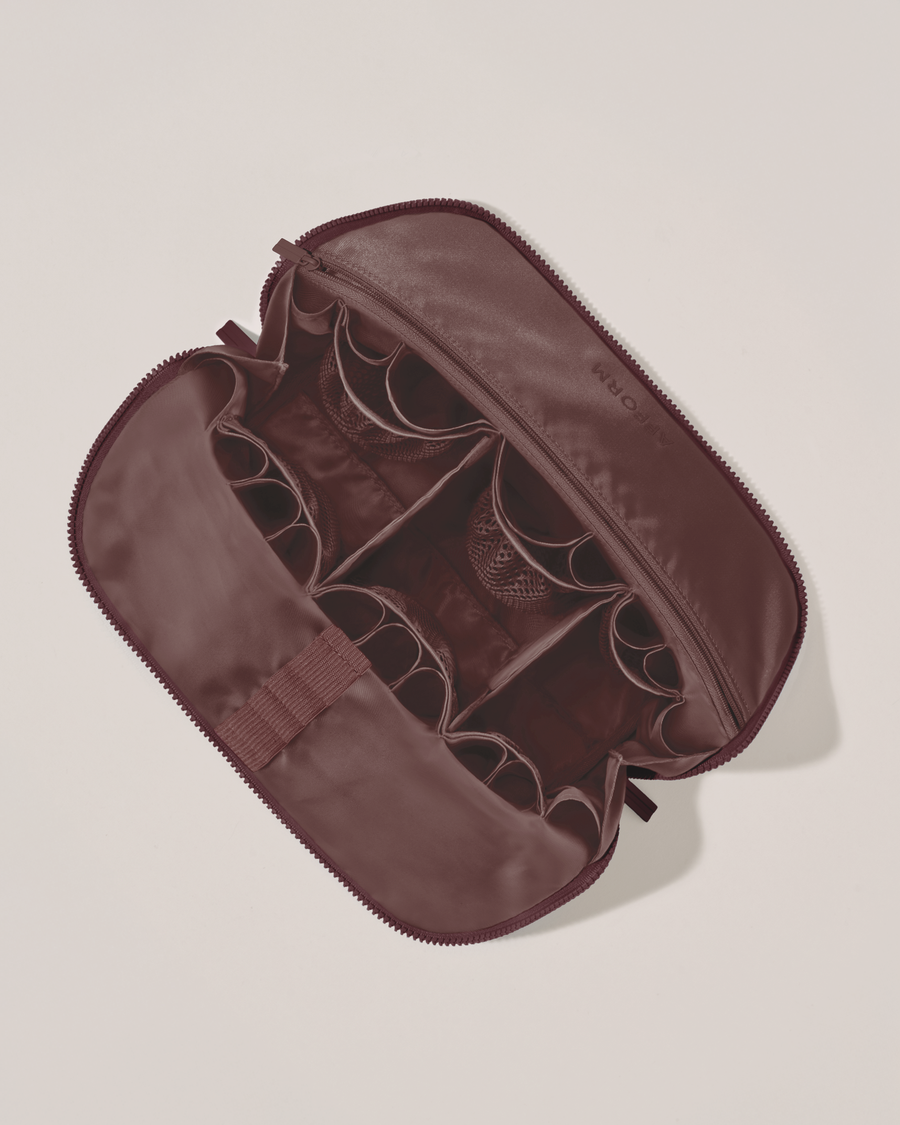 Interior view of Afform Large Cassis (maroon) Traveller makeup bag showing empty pockets, pouches, elastic holders, and zipper pocket for loose items