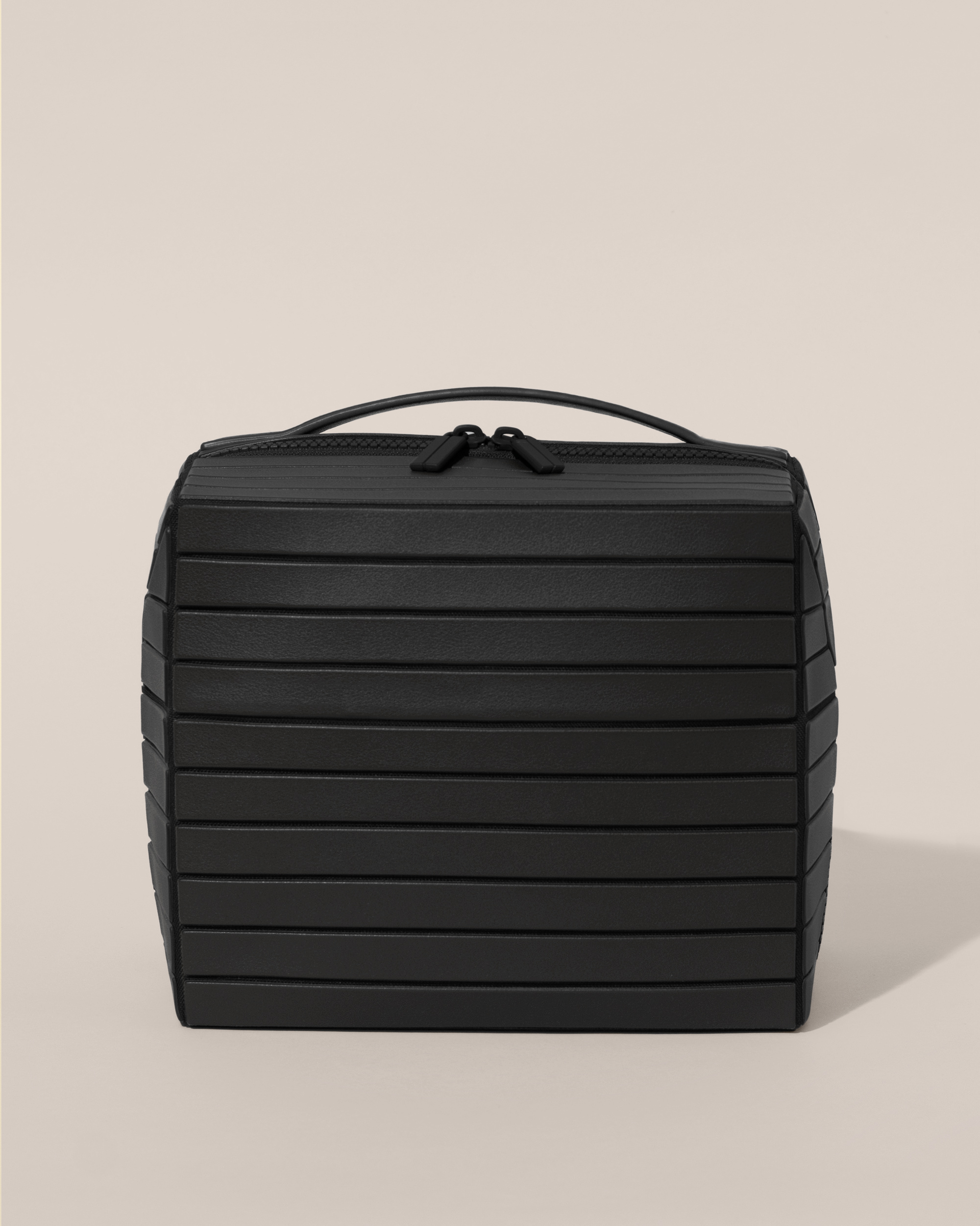 Front view of the closed Afform Onyx (black) Kit toiletry bag with a compact, zip-around design and top handle for elevated everyday or travel organization