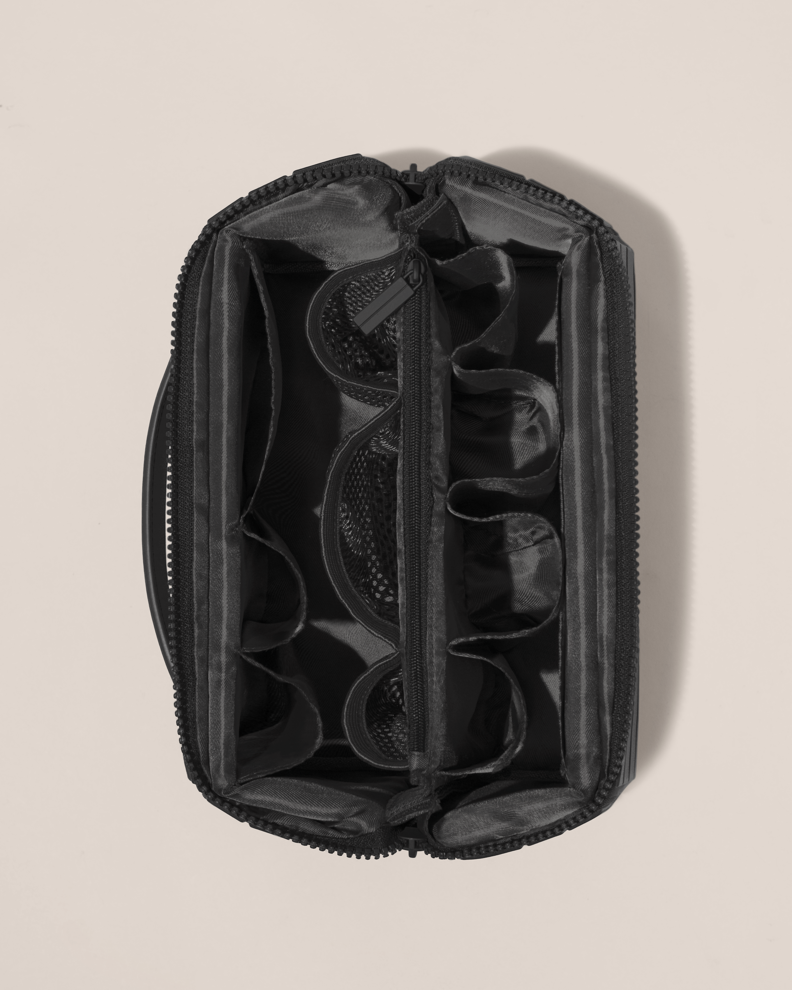 Overhead view of Afform Onyx (black) Kit toiletry bag, showcasing its structured interior with multiple compartments and mesh pockets for organized travel storage