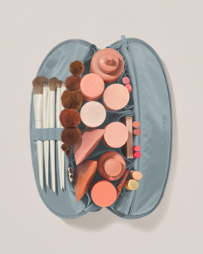 Image of the large traveller top down, open with a large assortment of products and makeup brushes inside of it.
