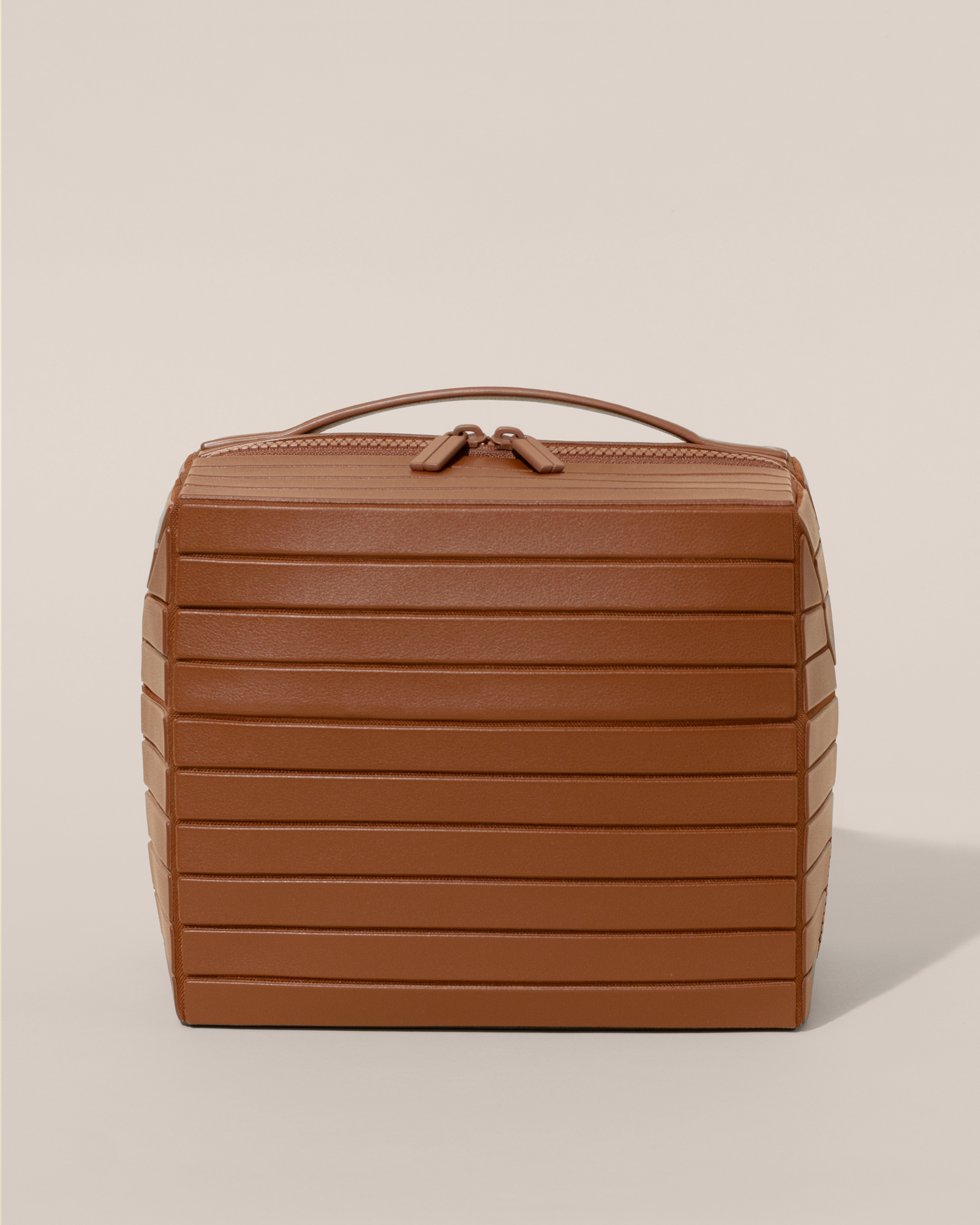 Front view of the closed Afform Large Vicuna (brown) Kit toiletry bag with a compact, zip-around design and top handle for elevated everyday or travel organization
