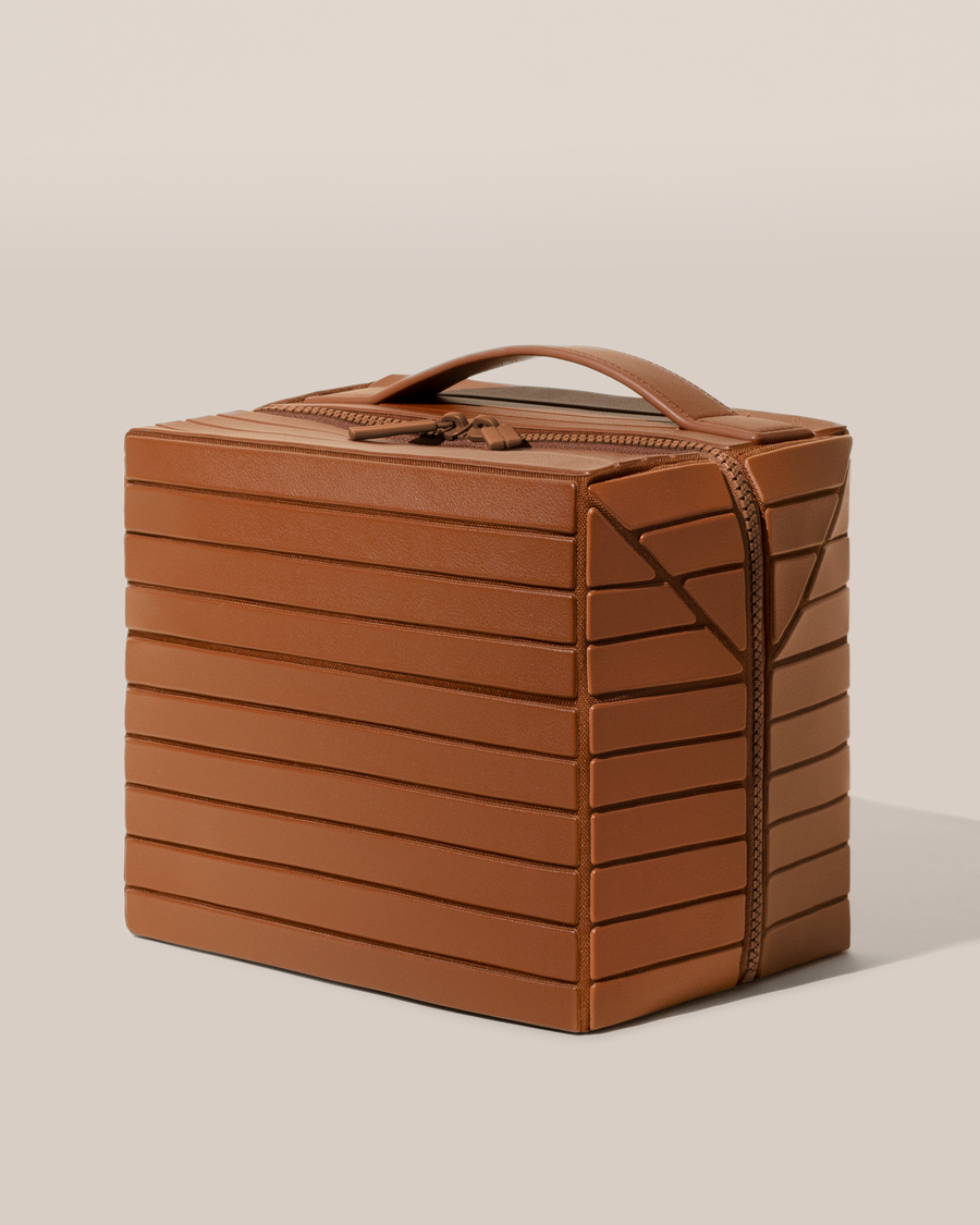 Side view of the closed Afform Large Vicuna (brown) Kit toiletry bag with a compact, zip-around design and top handle for elevated everyday or travel organization
