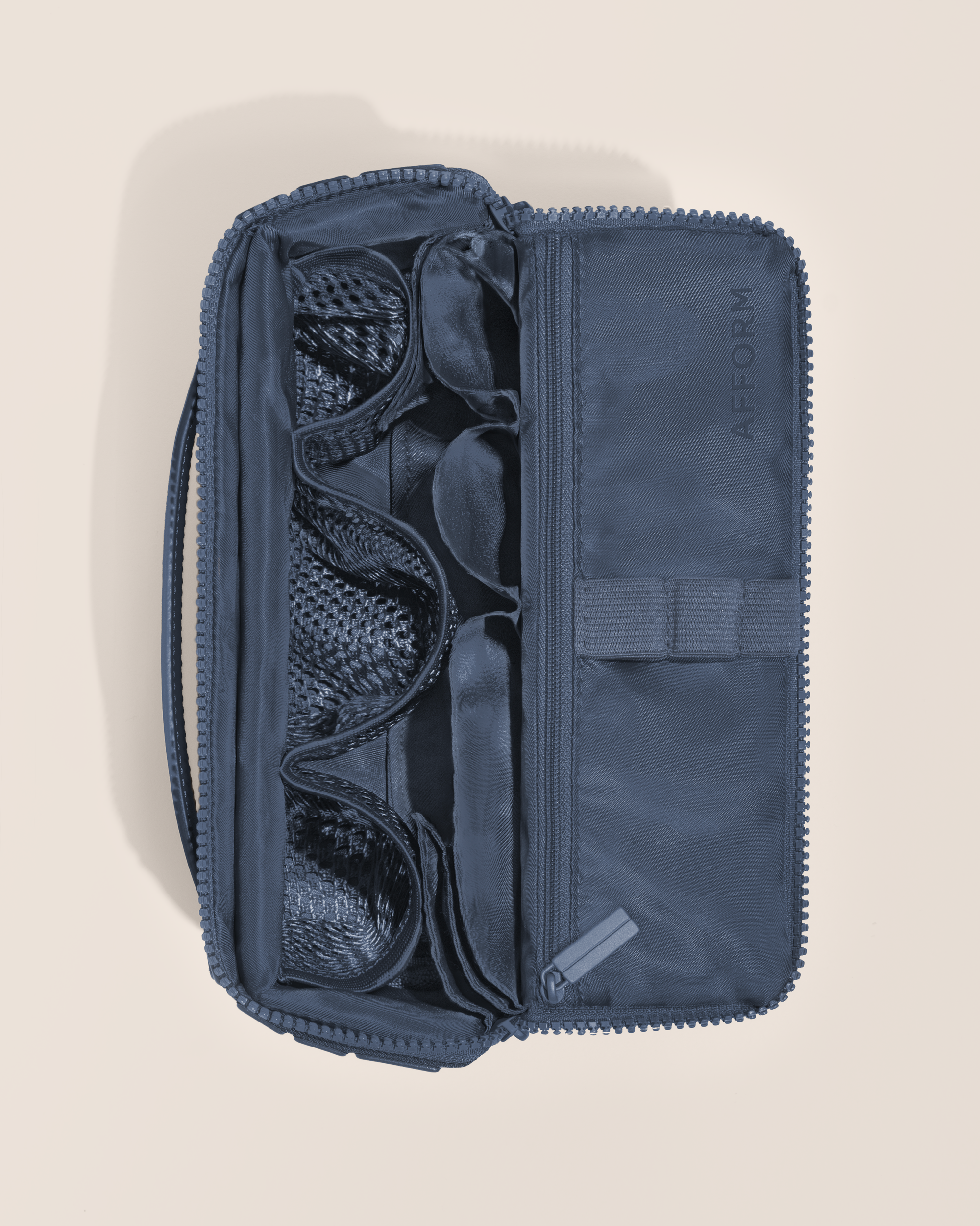 Overhead view of Afform Medium Indigo (blue) Kit toiletry bag, showcasing its structured interior with multiple compartments and mesh pockets for organized travel storage
