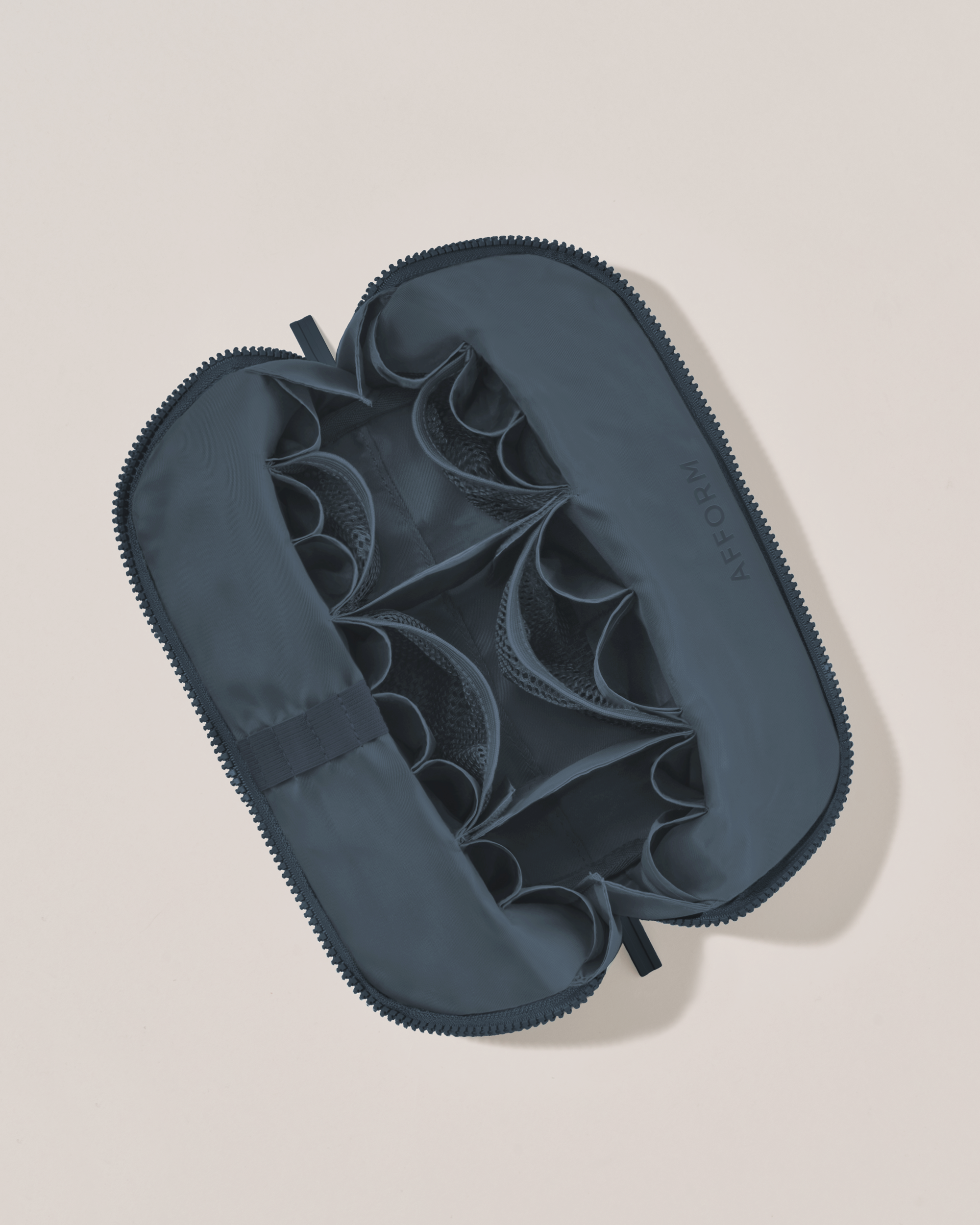 Interior view of Afform Medium Indigo (navy) Traveller makeup bag showing empty pockets, pouches, and elastic holders