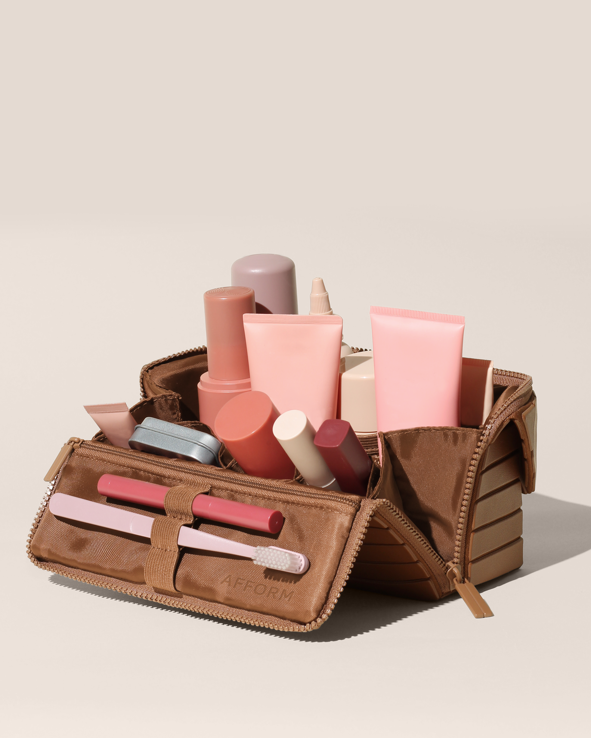 Open Afform Medium Vicuna (brown) Kit, shown open and packed with skincare and grooming products and expanded using its accordion opening