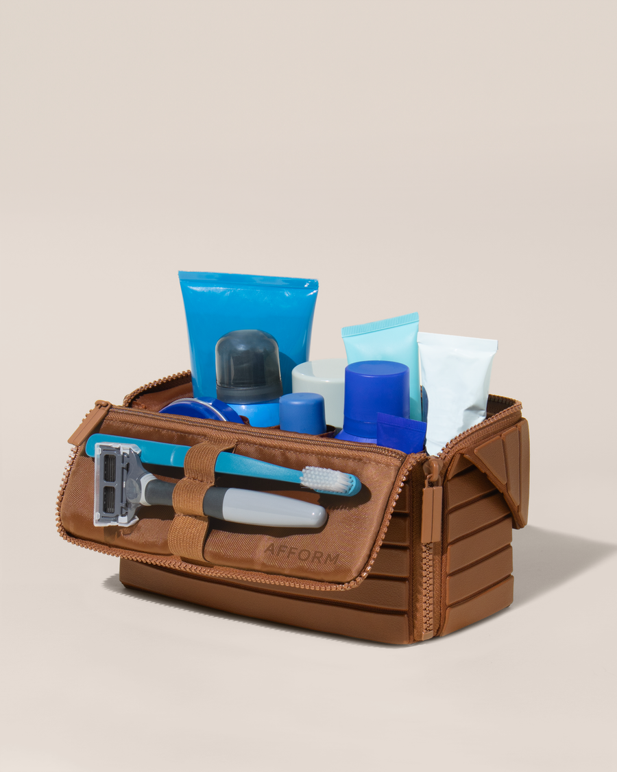 Open Afform Medium Vicuna (brown) Kit, shown open and packed with grooming essentials like razors, cologne, and skincare. A structured, travel-ready toiletry organizer