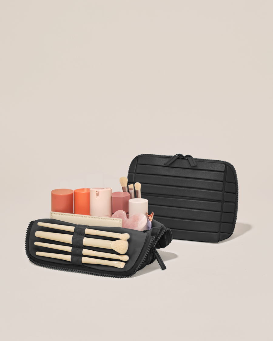 Open and closed Afform Small Onyx (black) Traveller makeup bag showing skincare, brushes, and curated travel essentials