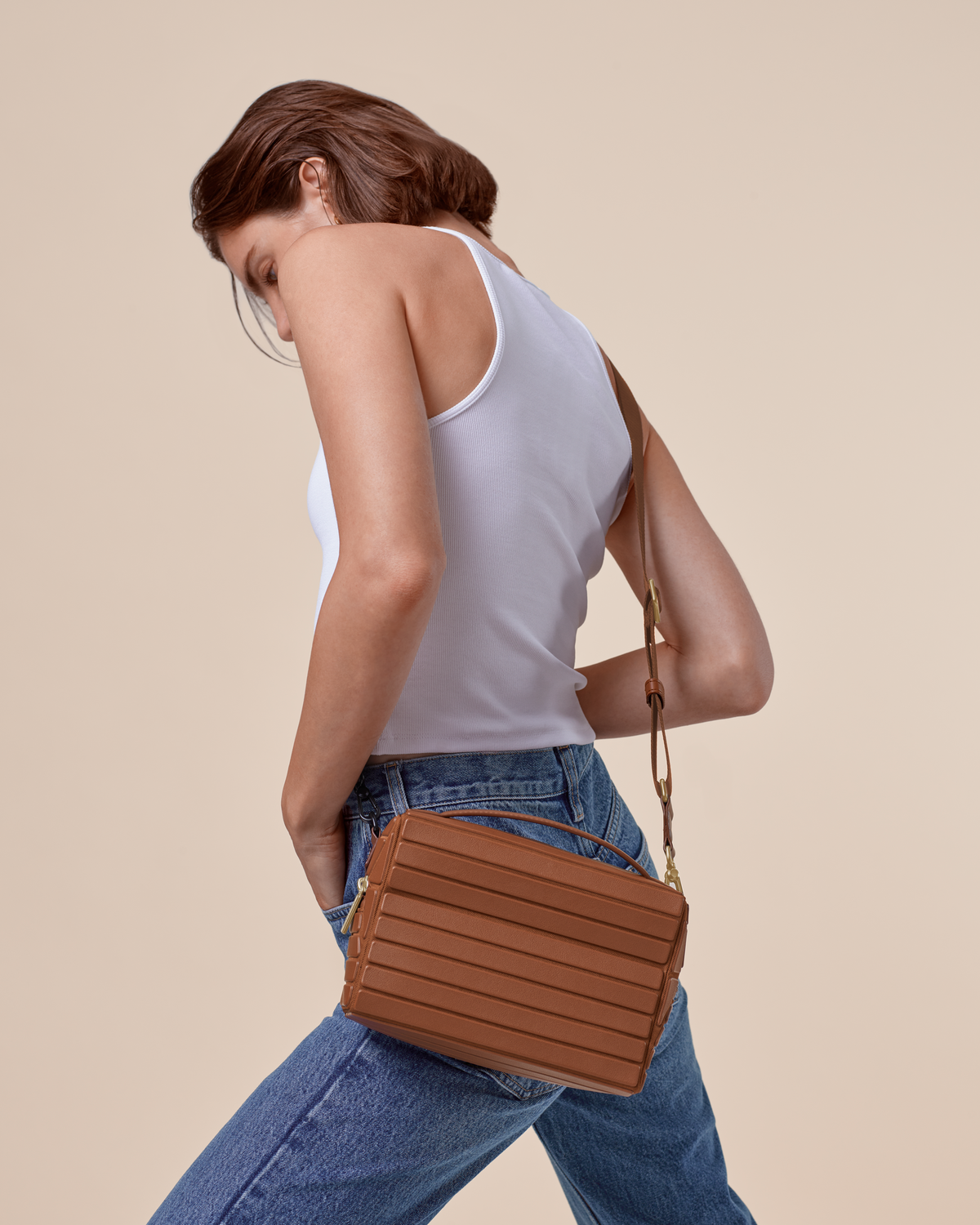 Model wearing the Vicuna Crossbody bag with a white tank top and jeans, showing the adjustable strap