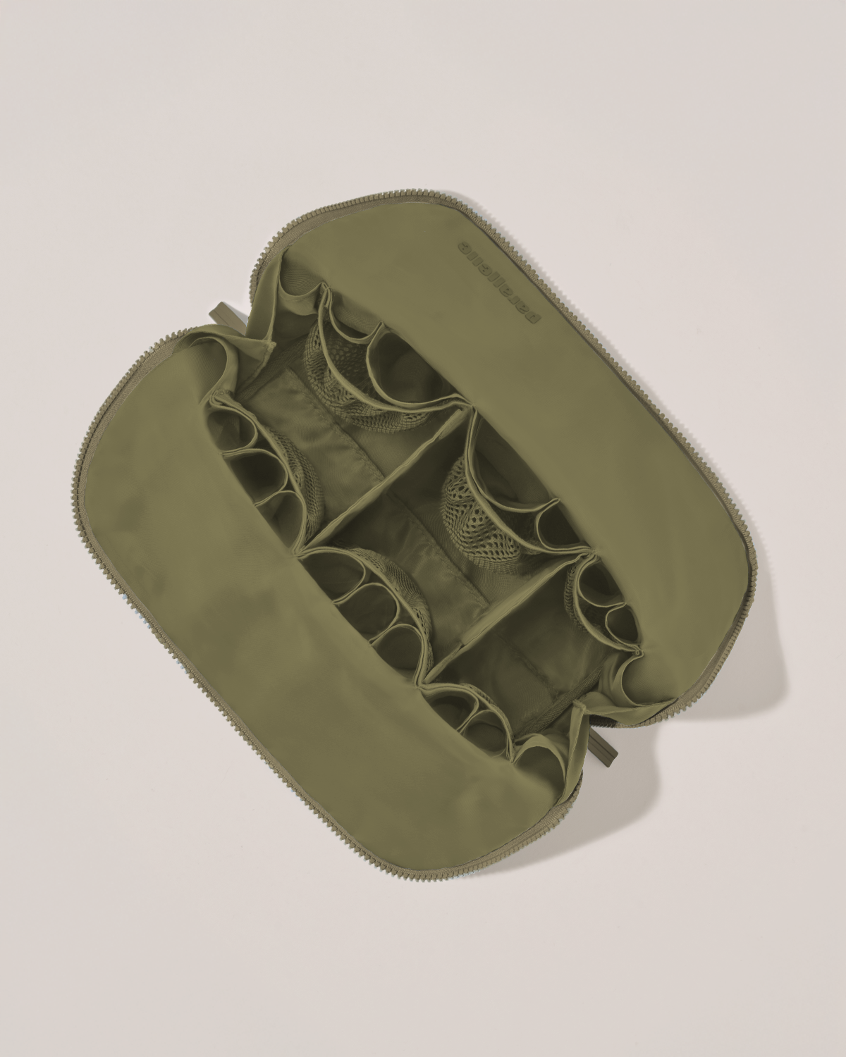 Interior view of Parallelle Large Olive (green) Traveller makeup bag showing empty pockets, pouches, and elastic holders