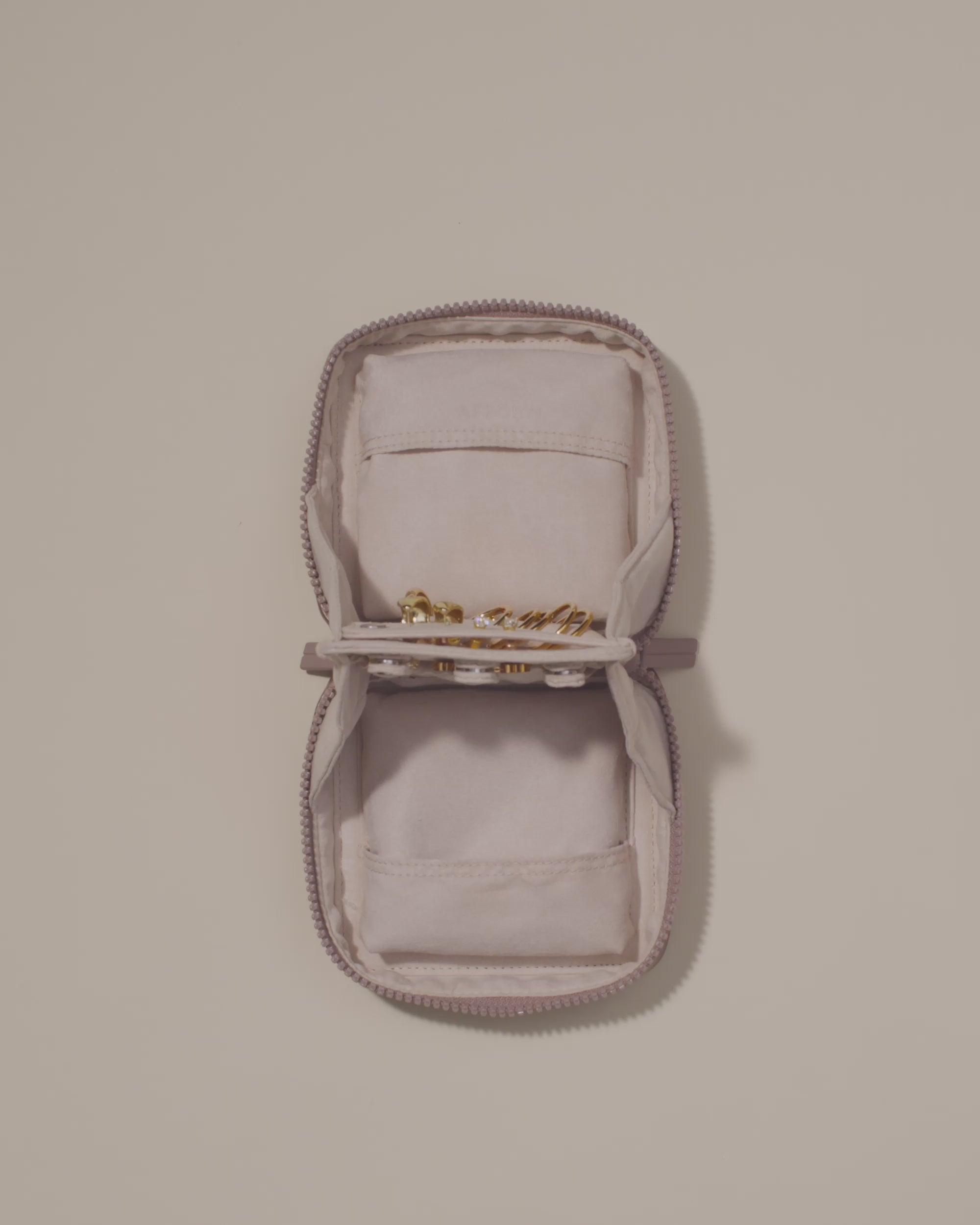 Video of the Small Vault showing its snaps being used to fasten and unfasten a necklace and a bracelet being removed from one of the extra compartment pouches